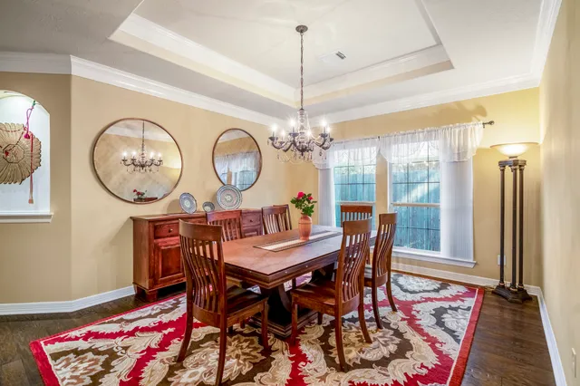 a view of a dining room with furniture a chandelier and wooden floor