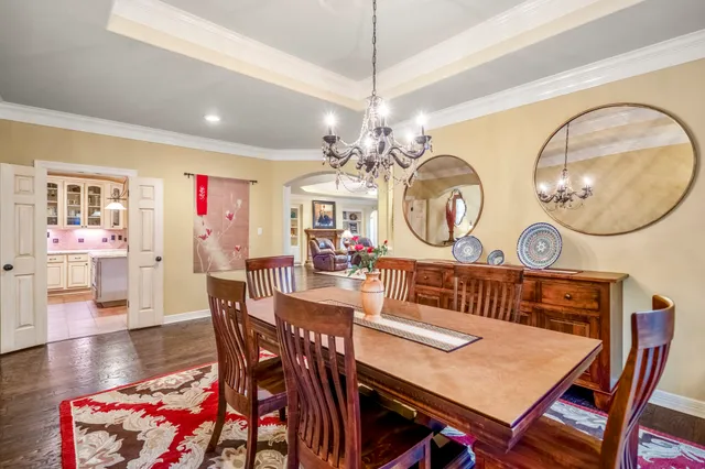 a living room with furniture large window and wooden floor