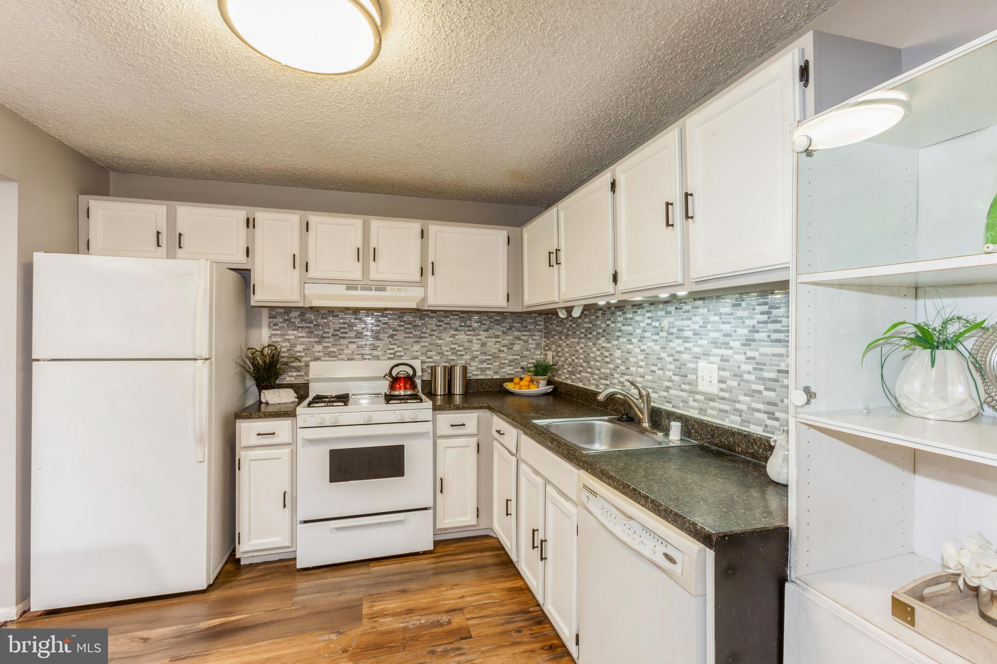 11833 Shire Court, Unit 12C Reston, VA 20191 - Photo 12 of 28 a kitchen with a sink a stove and refrigerator