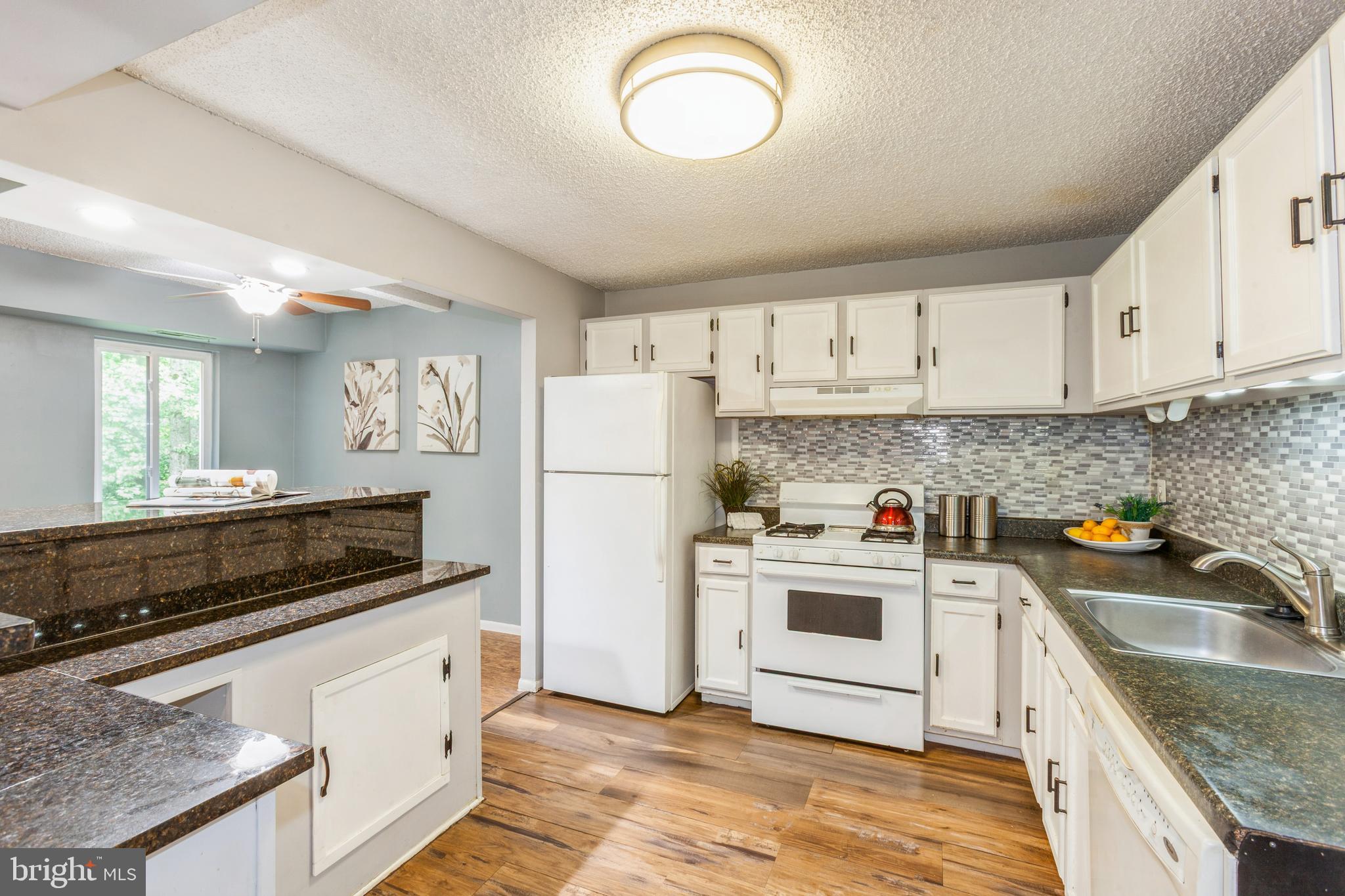 11833 Shire Court, Unit 12C Reston, VA 20191 - Photo 13 of 28 a kitchen with white cabinets and white appliances