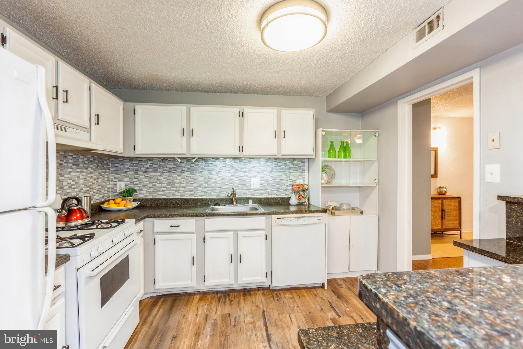 11833 Shire Court, Unit 12C Reston, VA 20191 - Photo 15 of 28 a kitchen with stainless steel appliances granite countertop a stove a sink and a refrigerator