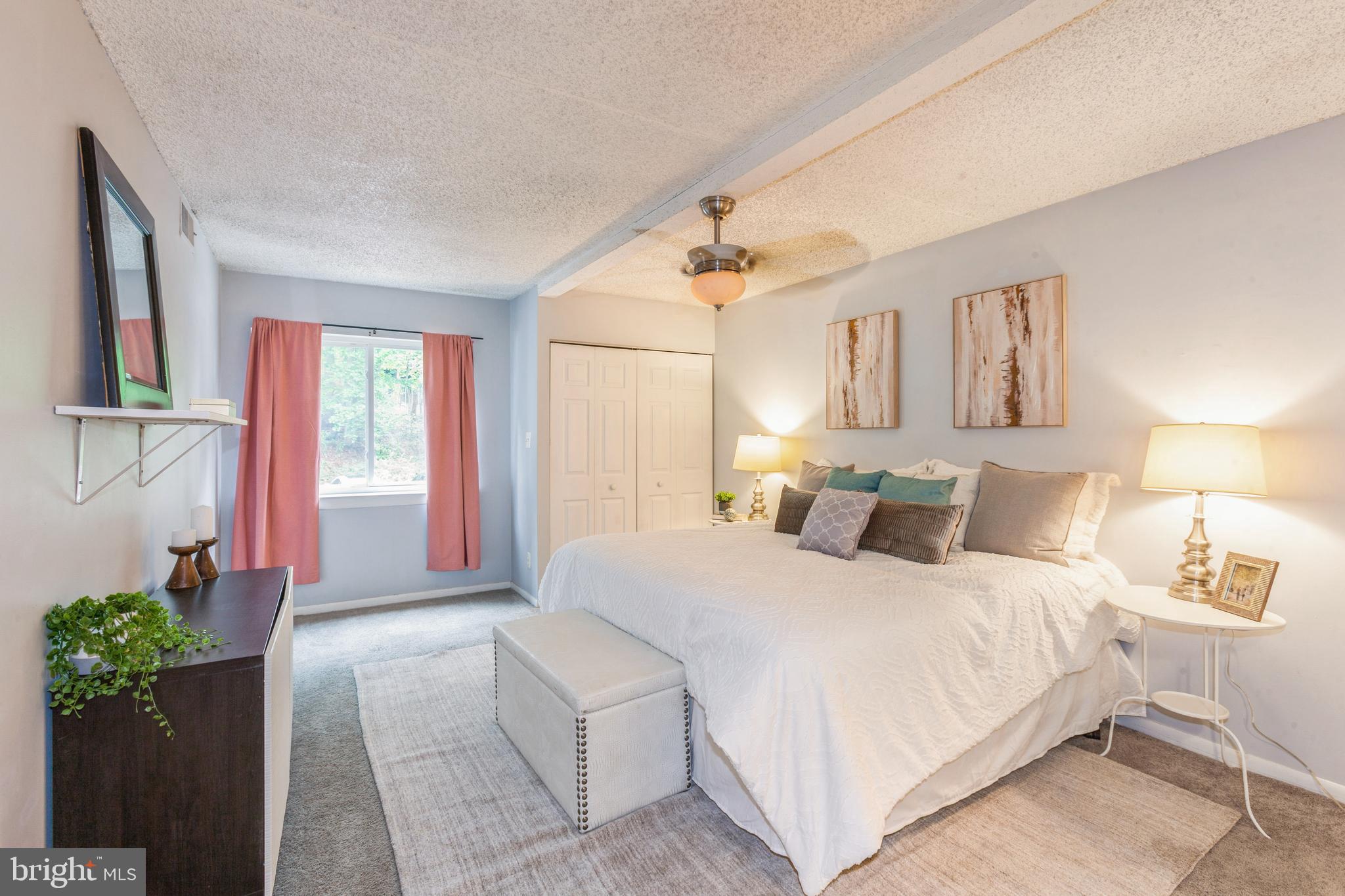 11833 Shire Court, Unit 12C Reston, VA 20191 - Photo 17 of 28 a bedroom with a large bed and a chandelier