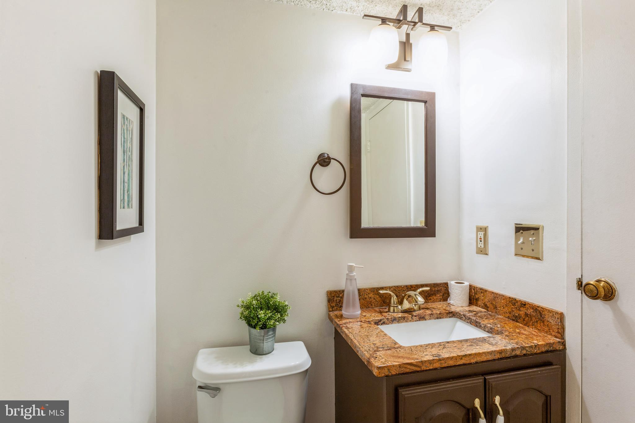 11833 Shire Court, Unit 12C Reston, VA 20191 - Photo 21 of 28 a bathroom with a granite countertop sink and a mirror