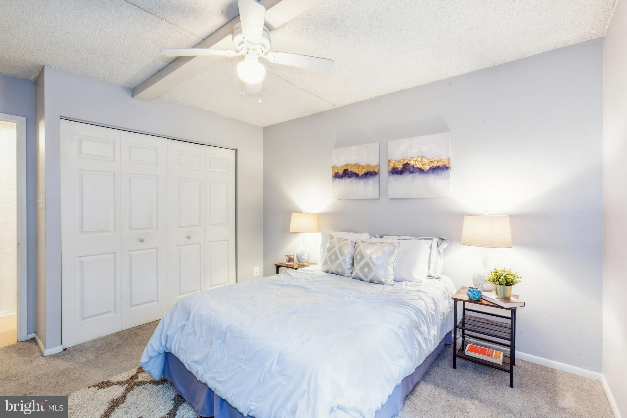 11833 Shire Court, Unit 12C Reston, VA 20191 - Photo 24 of 28 a bedroom with a bed and a chandelier