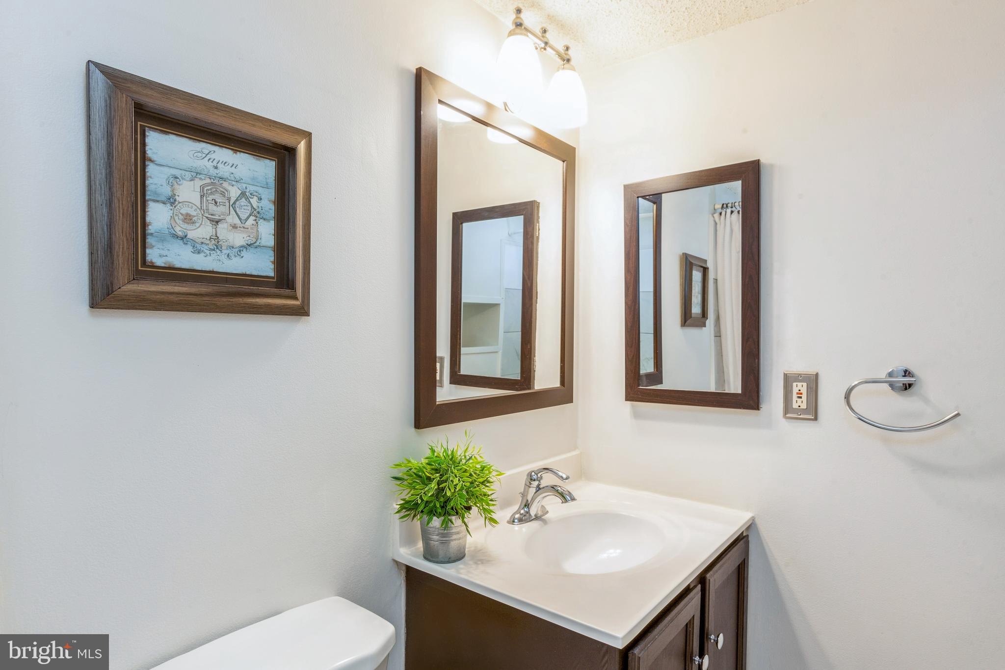 11833 Shire Court, Unit 12C Reston, VA 20191 - Photo 25 of 28 a bathroom with a sink mirror and vanity