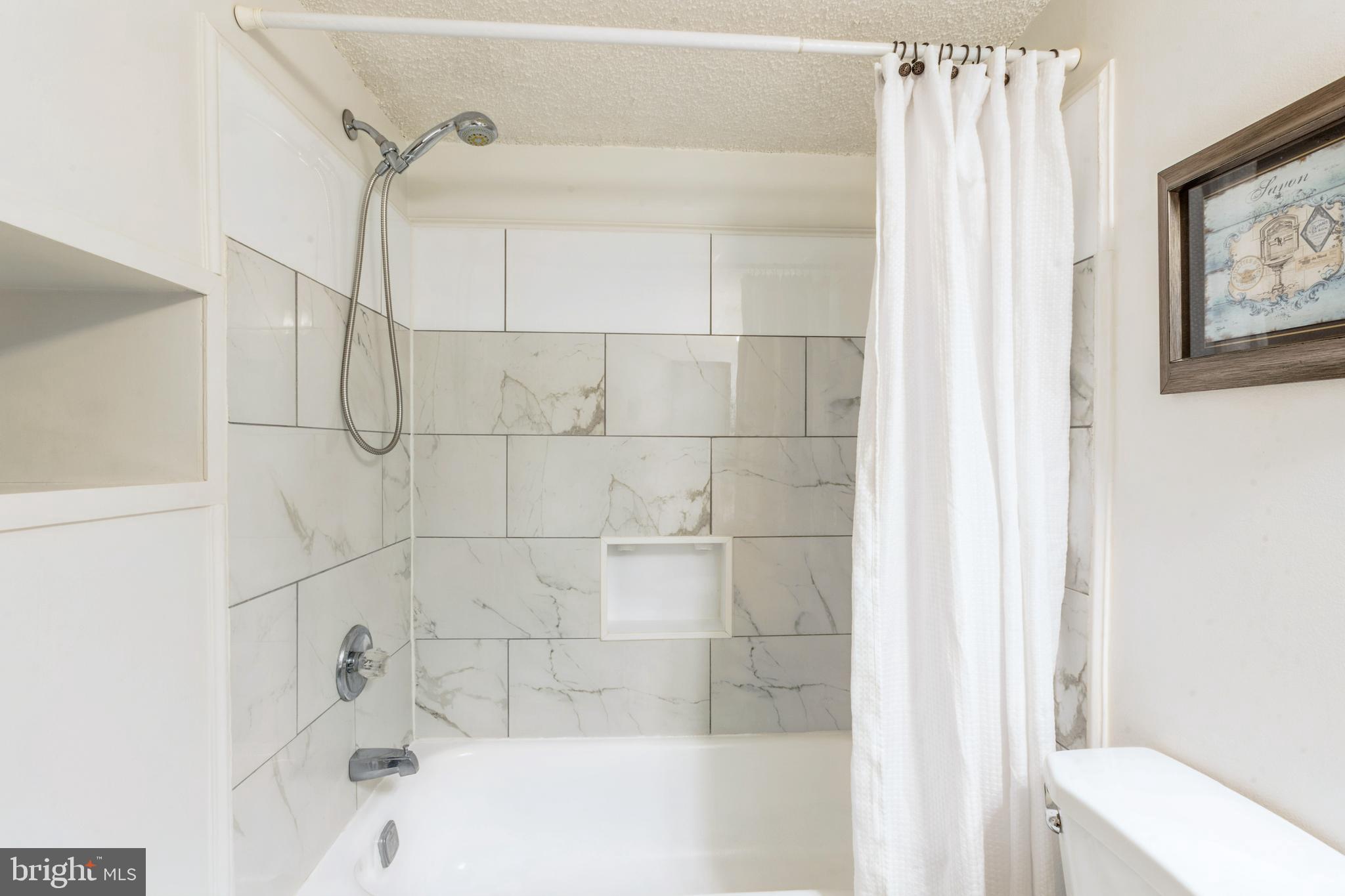 11833 Shire Court, Unit 12C Reston, VA 20191 - Photo 26 of 28 a bathroom with a bathtub and shower
