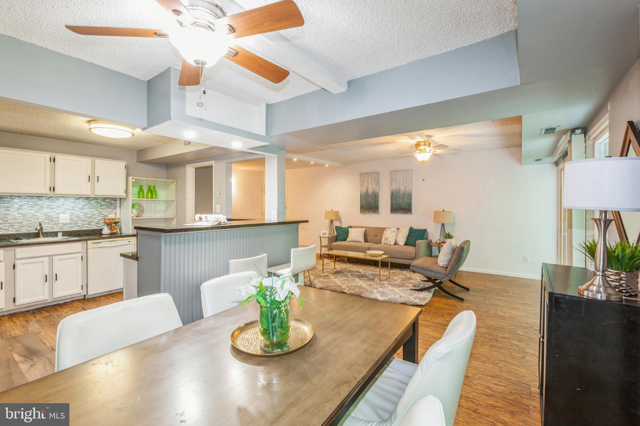 11833 Shire Court, Unit 12C Reston, VA 20191 - Photo 9 of 28 a kitchen with a dining table cabinets and living room view