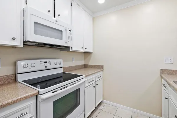 a kitchen with granite countertop white cabinets and white appliances