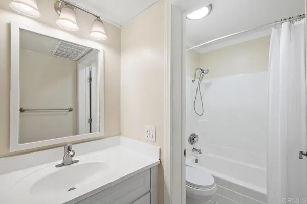a bathroom with a granite countertop sink a toilet and shower
