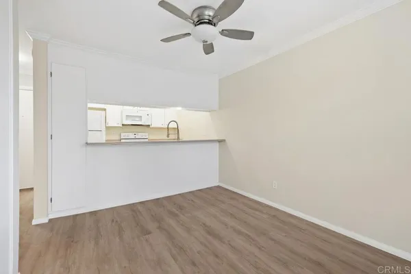 a view of a kitchen with wooden floor and a ceiling fan
