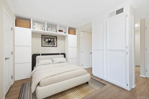 a bedroom with a bed and painting on the wall