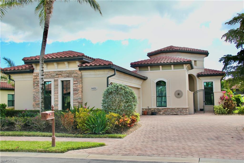 9321 Vercelli Court Naples, FL 34113 - Photo 1 of 49 a front view of a house with a garden and plants