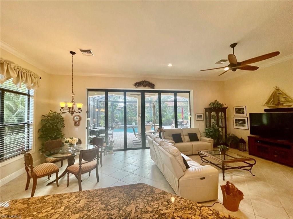 9321 Vercelli Court Naples, FL 34113 - Photo 12 of 49 a living room with furniture floor to ceiling window and a flat screen tv