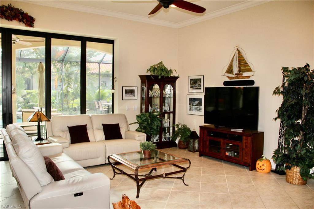 9321 Vercelli Court Naples, FL 34113 - Photo 14 of 49 a living room with furniture a flat screen tv and a large window