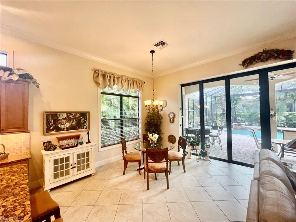 9321 Vercelli Court Naples, FL 34113 - Photo 17 of 49 a living room with furniture a flat screen tv and a floor to ceiling window