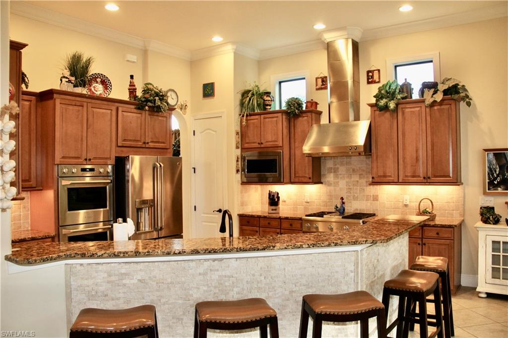 9321 Vercelli Court Naples, FL 34113 - Photo 19 of 49 a kitchen with stainless steel appliances granite countertop a sink and a refrigerator
