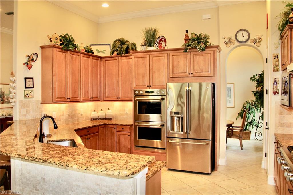 9321 Vercelli Court Naples, FL 34113 - Photo 20 of 49 a kitchen with stainless steel appliances granite countertop a refrigerator a stove and a sink