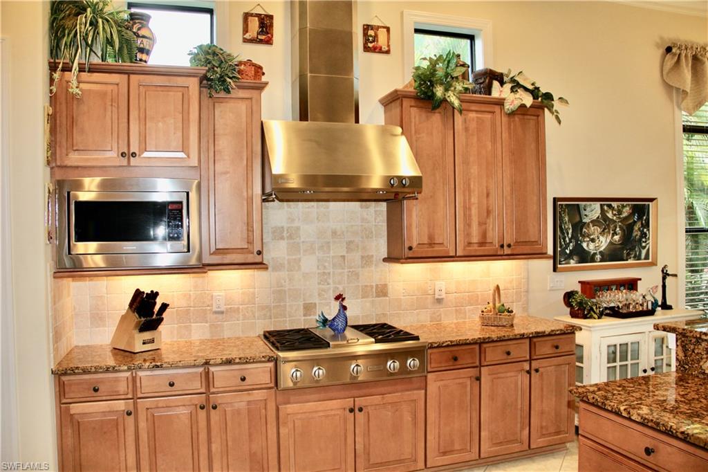 9321 Vercelli Court Naples, FL 34113 - Photo 21 of 49 a kitchen with stainless steel appliances a stove and a microwave