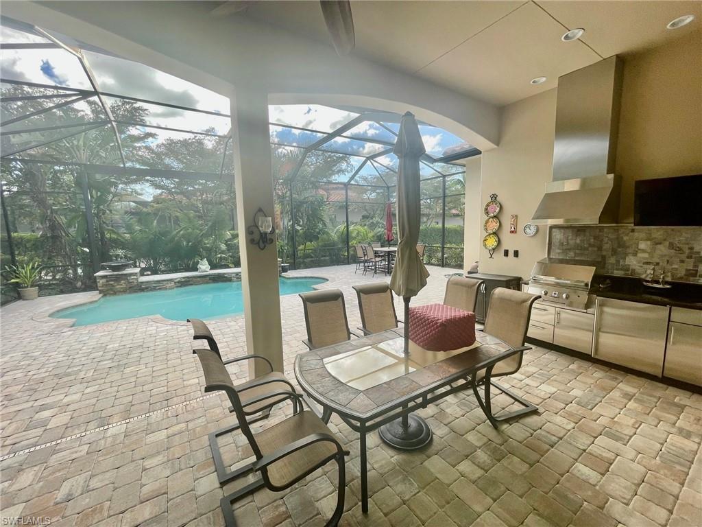9321 Vercelli Court Naples, FL 34113 - Photo 25 of 49 a living room with furniture and a floor to ceiling window