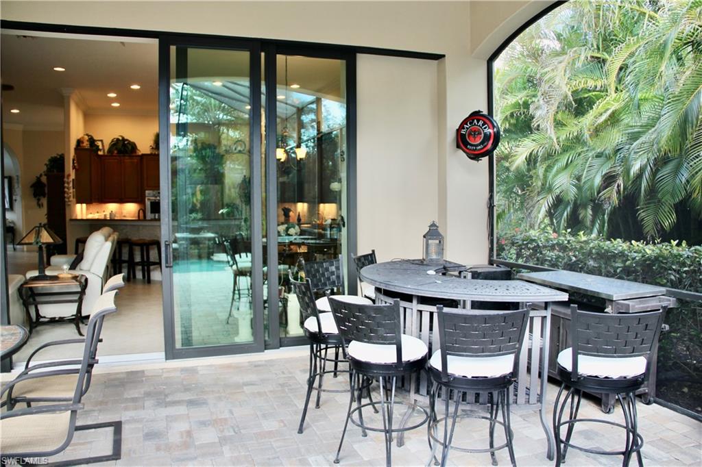 9321 Vercelli Court Naples, FL 34113 - Photo 31 of 49 a view of an outdoor dining space with a table and chairs
