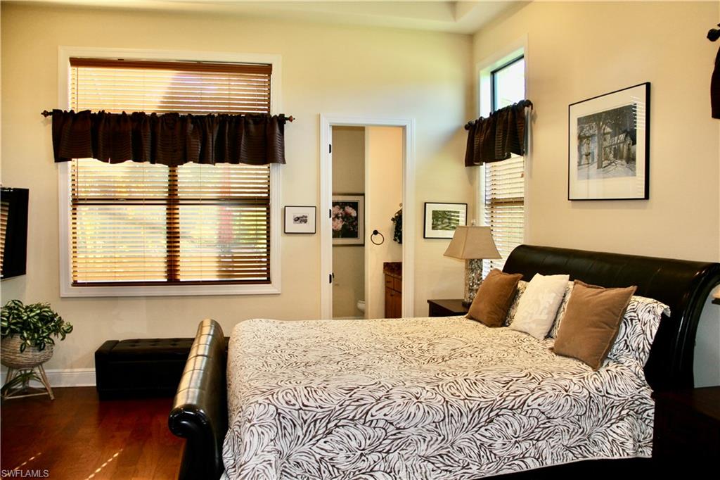 9321 Vercelli Court Naples, FL 34113 - Photo 37 of 49 a bedroom with a bed and wooden floor