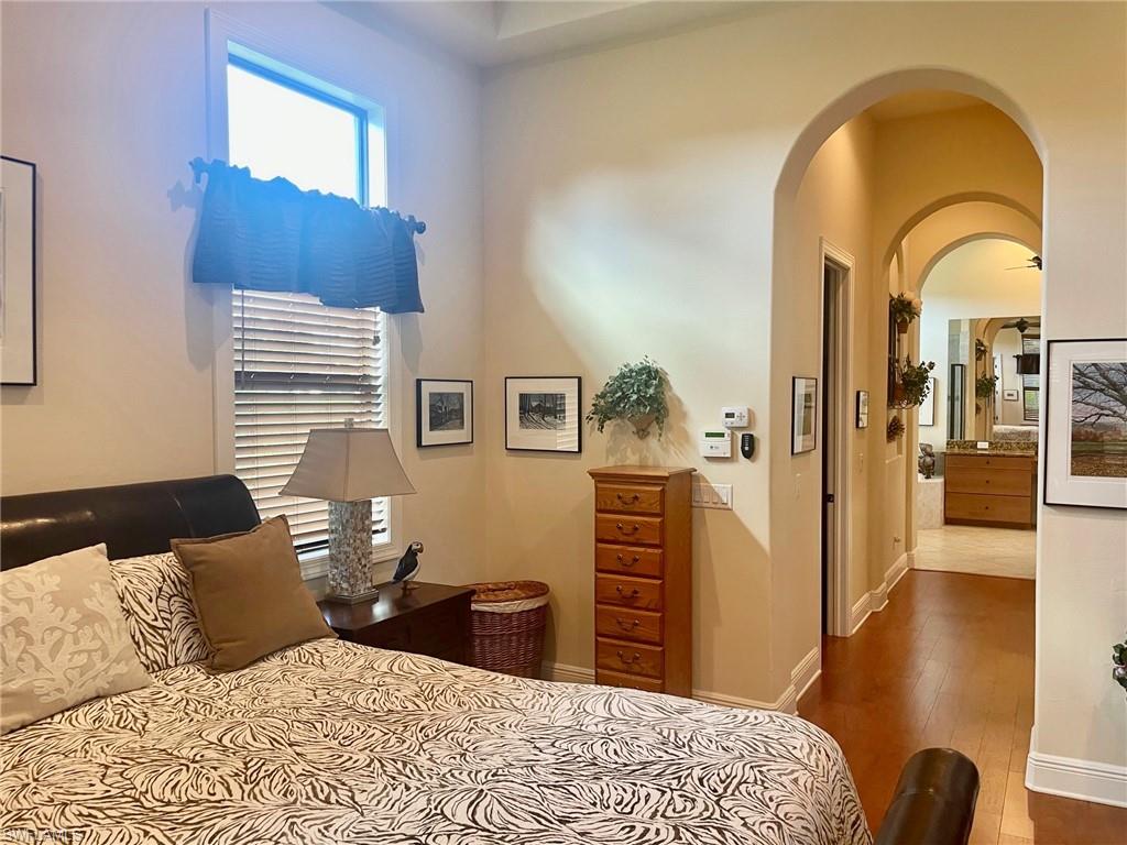 9321 Vercelli Court Naples, FL 34113 - Photo 39 of 49 a bedroom with a bed and wooden floor