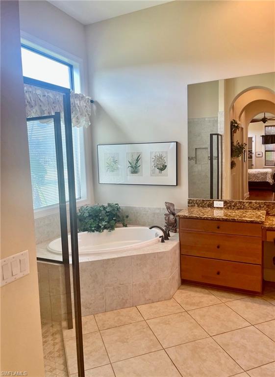 9321 Vercelli Court Naples, FL 34113 - Photo 41 of 49 a bathroom with a tub a double vanity sink and a mirror