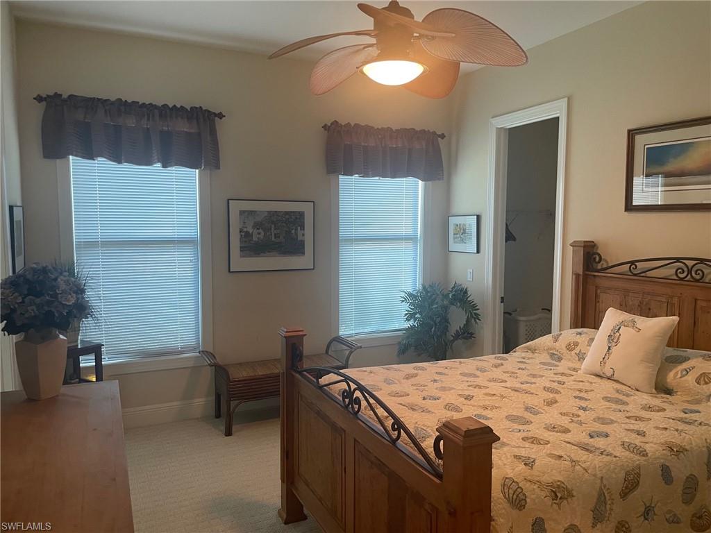 9321 Vercelli Court Naples, FL 34113 - Photo 43 of 49 a spacious bedroom with a bed and a table in it