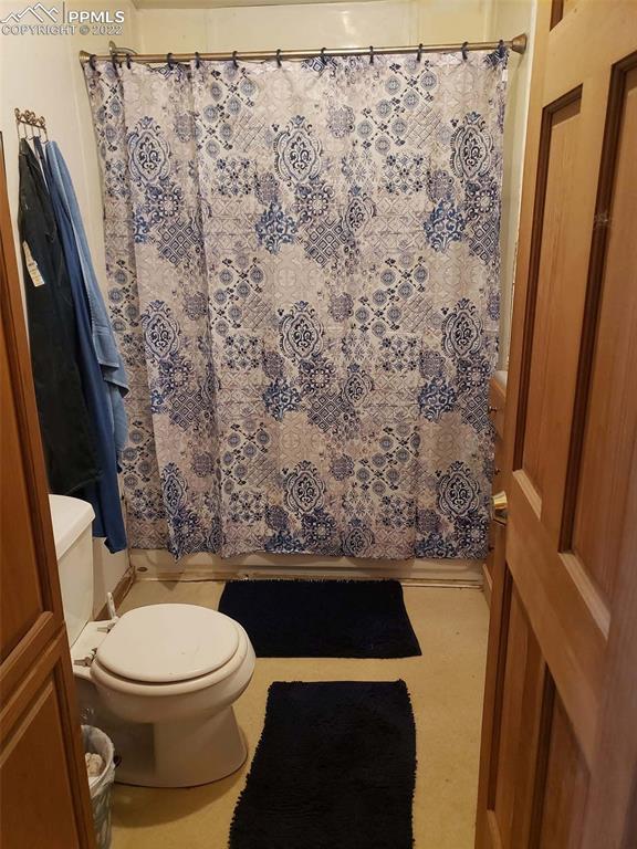18761 County Road J Ordway, CO 81063 - Photo 6 of 26 a white toilet sitting next to a shower curtain