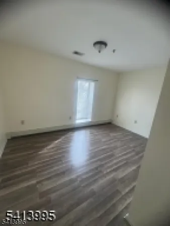 a view of an empty room and wooden floor