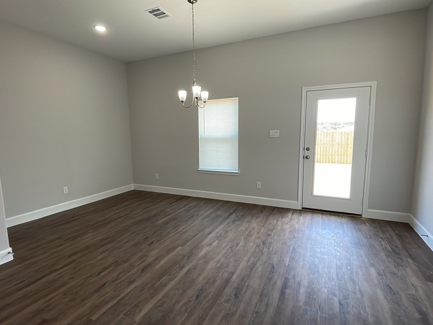 798 County Road 5702 Cleveland, TX 77327 - Photo 11 of 25 an empty room with wooden floor and windows