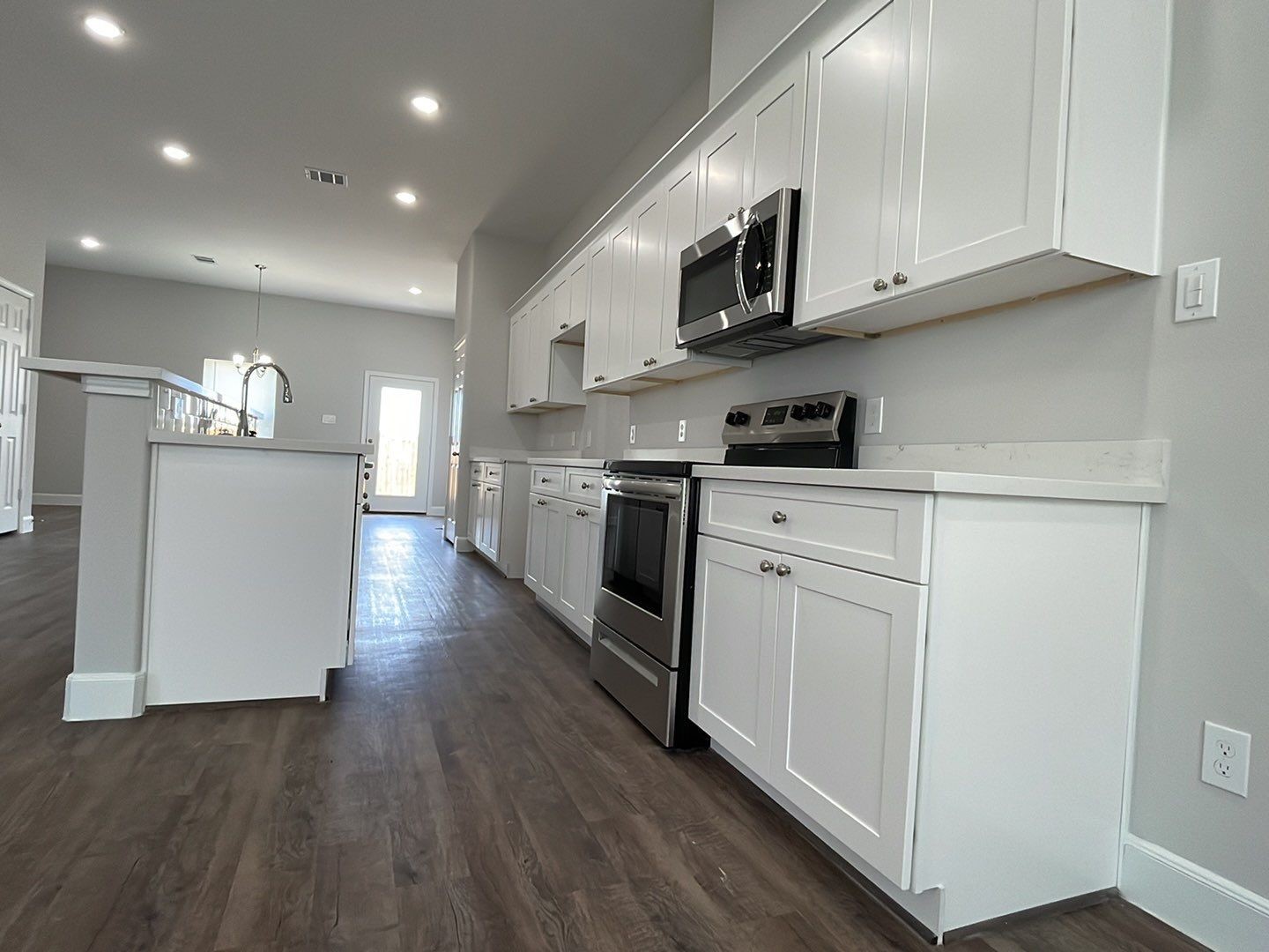 798 County Road 5702 Cleveland, TX 77327 - Photo 3 of 25 a kitchen with stainless steel appliances granite countertop a stove top oven a sink dishwasher and white cabinets with wooden floor