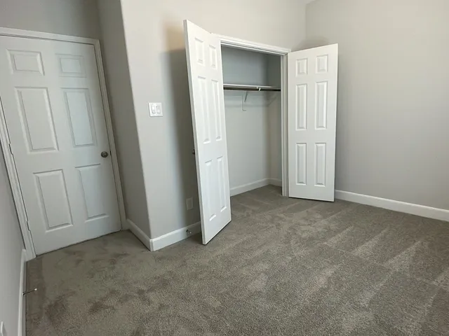 an empty room with closet and windows
