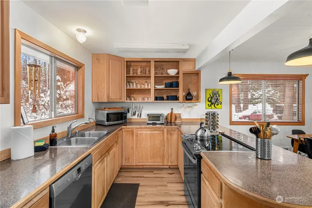 a kitchen with stainless steel appliances granite countertop a sink a stove counter space and a window