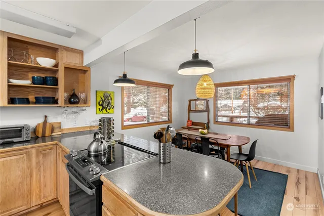 a dining room with wooden floor a chandelier a wooden table and chairs