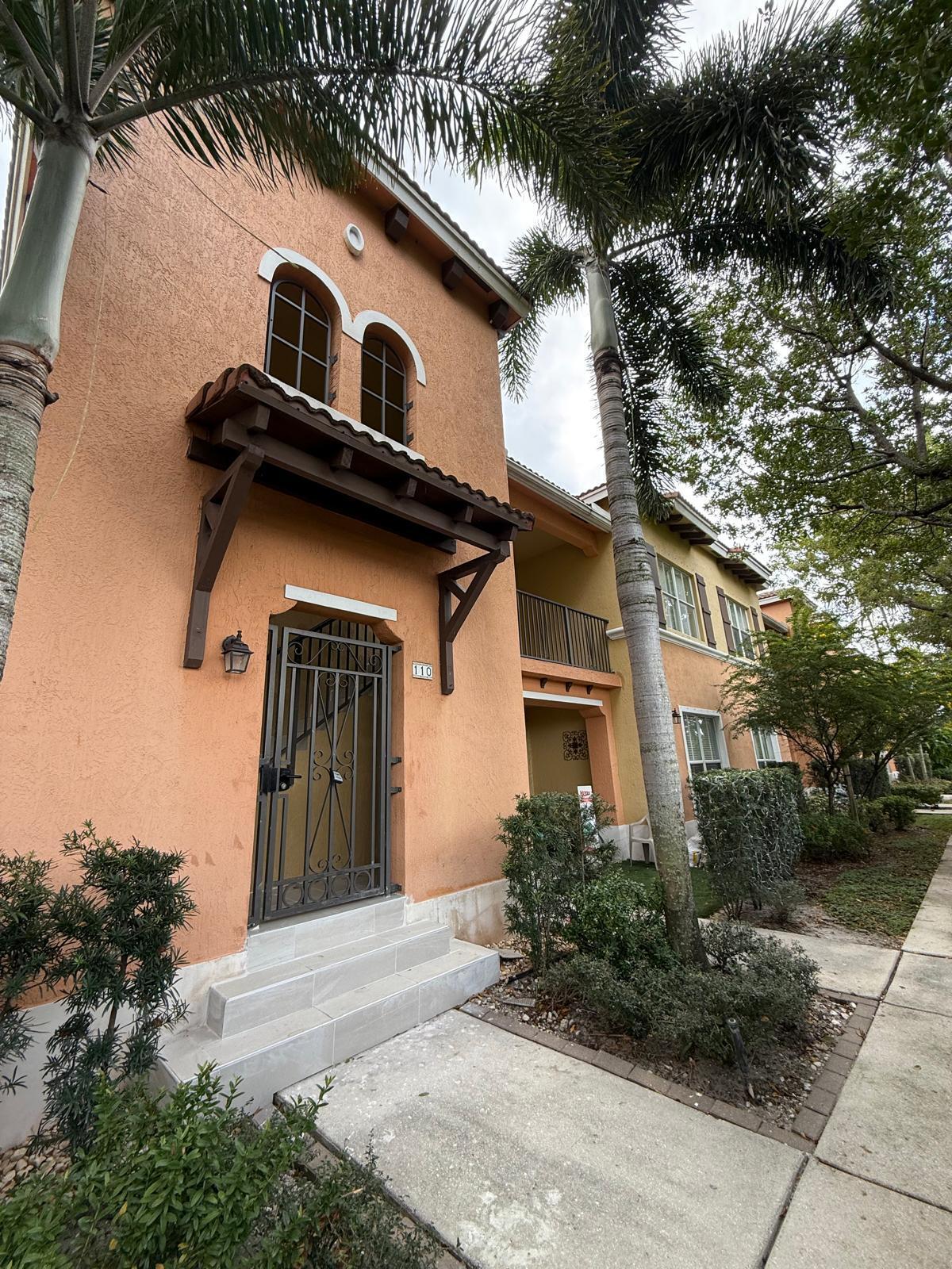 3569 Forest Hill Boulevard, Unit 110 Palm Springs, FL 33406 - Photo 3 of 23 a front view of a house with garden