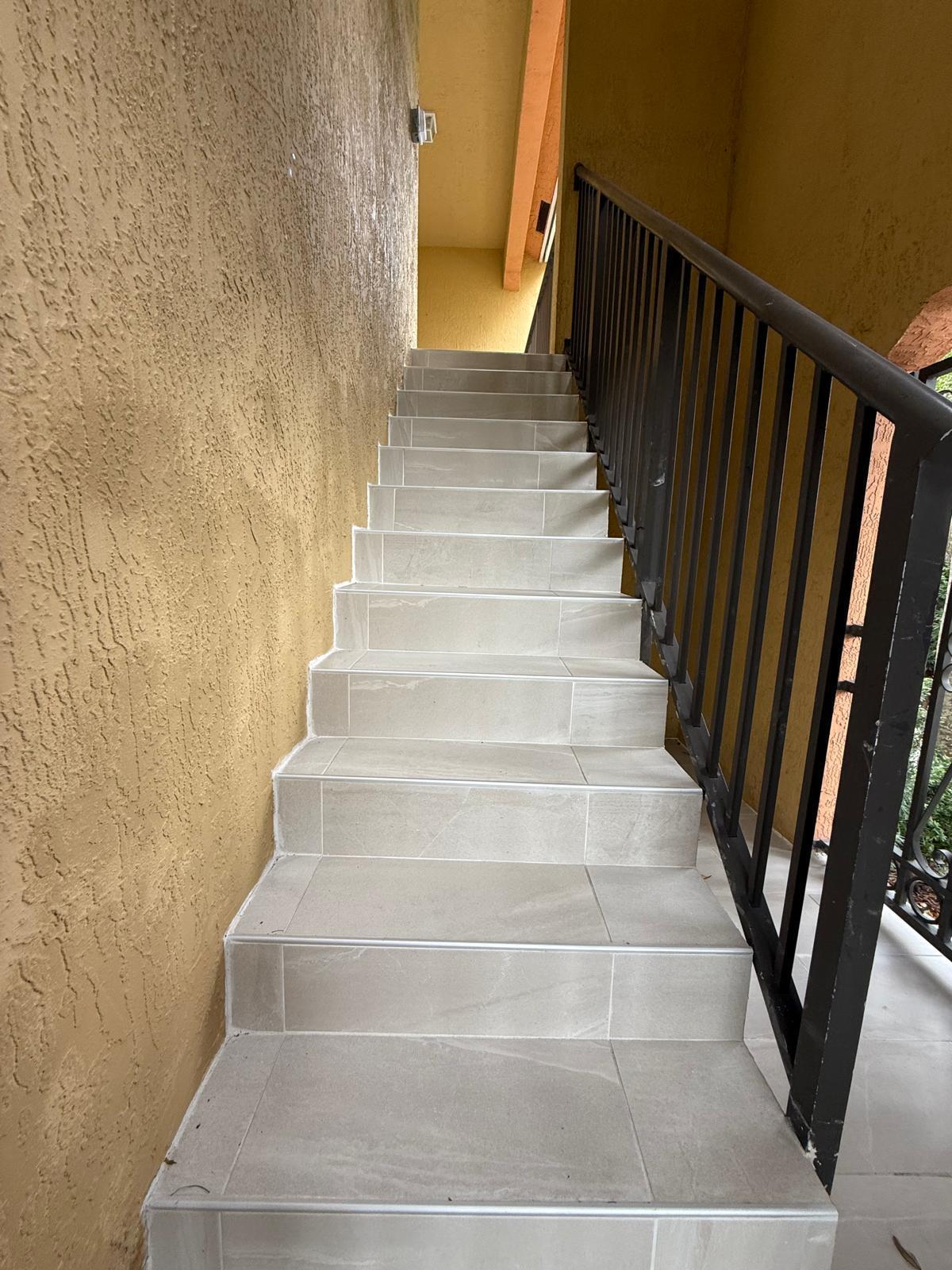 3569 Forest Hill Boulevard, Unit 110 Palm Springs, FL 33406 - Photo 5 of 23 a view of staircase with white walls and a window