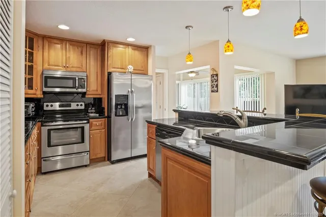 a kitchen with stainless steel appliances granite countertop a stove refrigerator and microwave