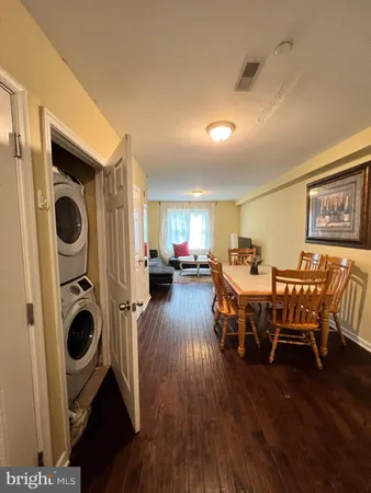 a living room with furniture a flat screen tv and kitchen view