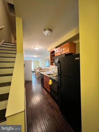 a living room with stainless steel appliances furniture and a kitchen view