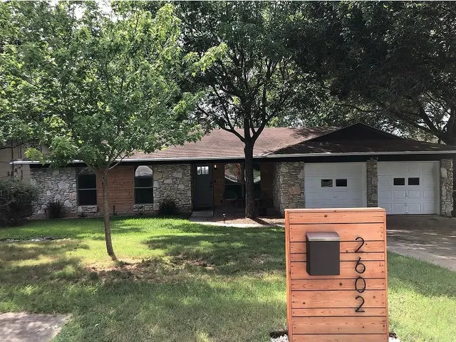 a front view of a house with a yard garage and outdoor seating