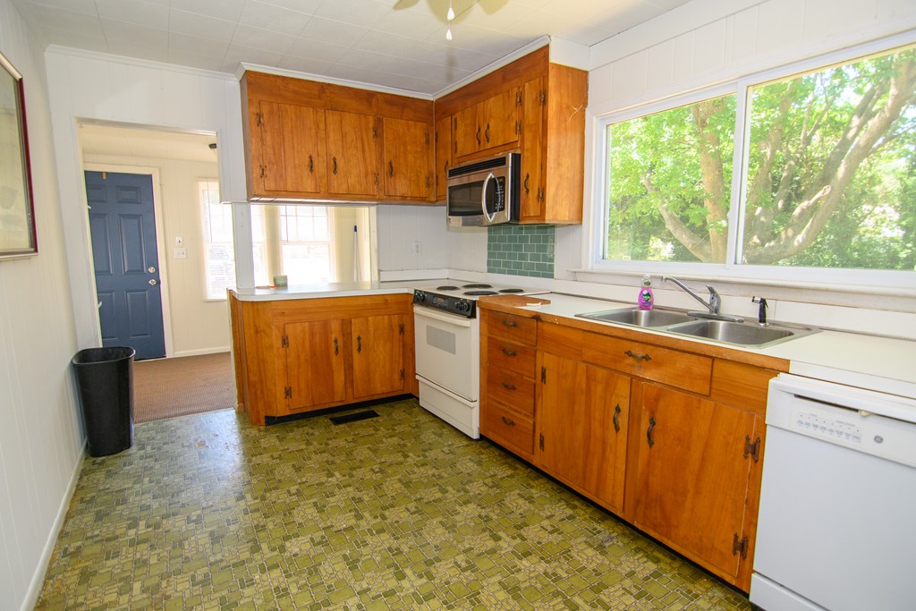 24432 Maxwell Street Parksley, VA 23421 - Photo 7 of 39 a kitchen with stainless steel appliances granite countertop a sink stove and cabinets