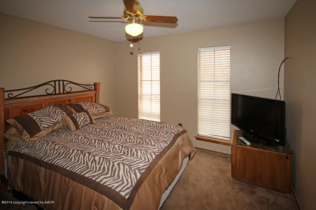 5320 Wheeler Lane Amarillo, TX 79110 - Photo 17 of 23 a bedroom with a bed and a flat screen tv