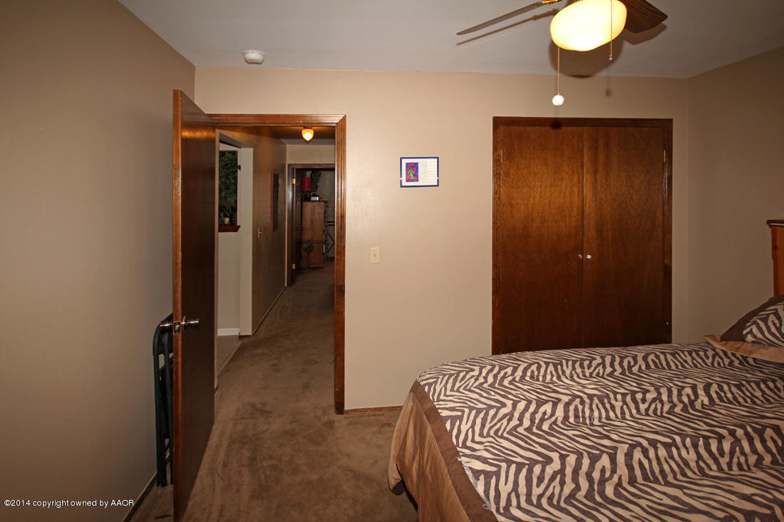5320 Wheeler Lane Amarillo, TX 79110 - Photo 18 of 23 a bedroom with a bed and a chandelier