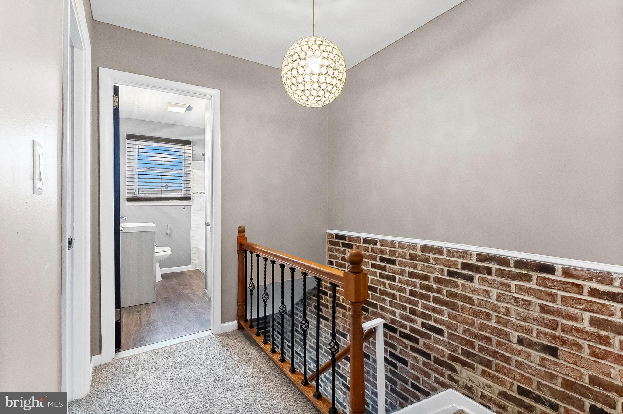 6955 Blanche Road Baltimore, MD 21215 - Photo 12 of 26 a view of a hallway with wooden floor and a bathroom