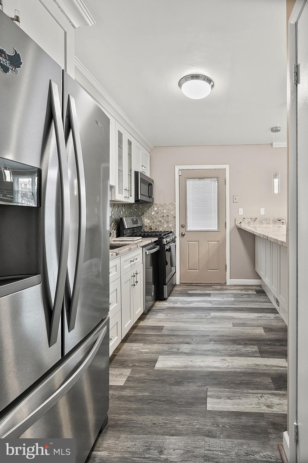 6955 Blanche Road Baltimore, MD 21215 - Photo 6 of 26 a kitchen with stainless steel appliances granite countertop a refrigerator and a sink