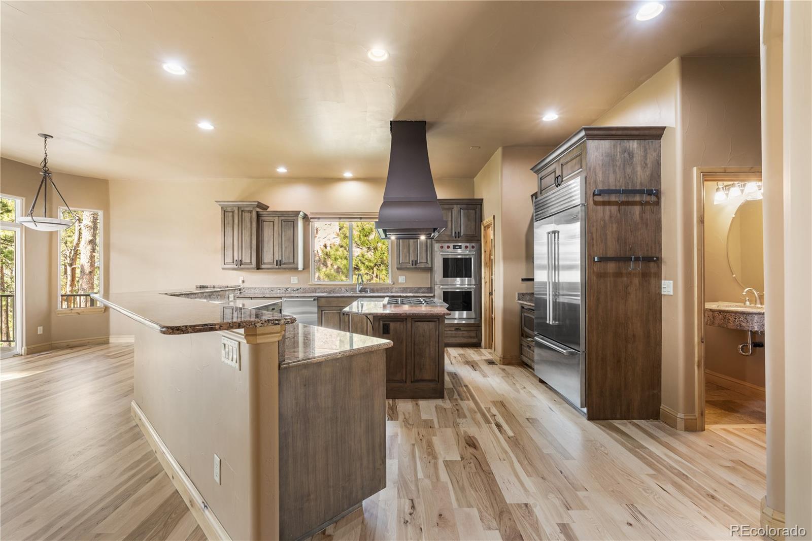 691 Cumberland Road Larkspur, CO 80118 - Photo 12 of 43 a kitchen with stainless steel appliances kitchen island granite countertop a refrigerator and a stove top oven