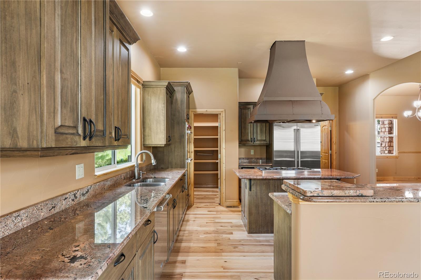 691 Cumberland Road Larkspur, CO 80118 - Photo 14 of 43 a kitchen with stainless steel appliances kitchen island granite countertop a sink and cabinets