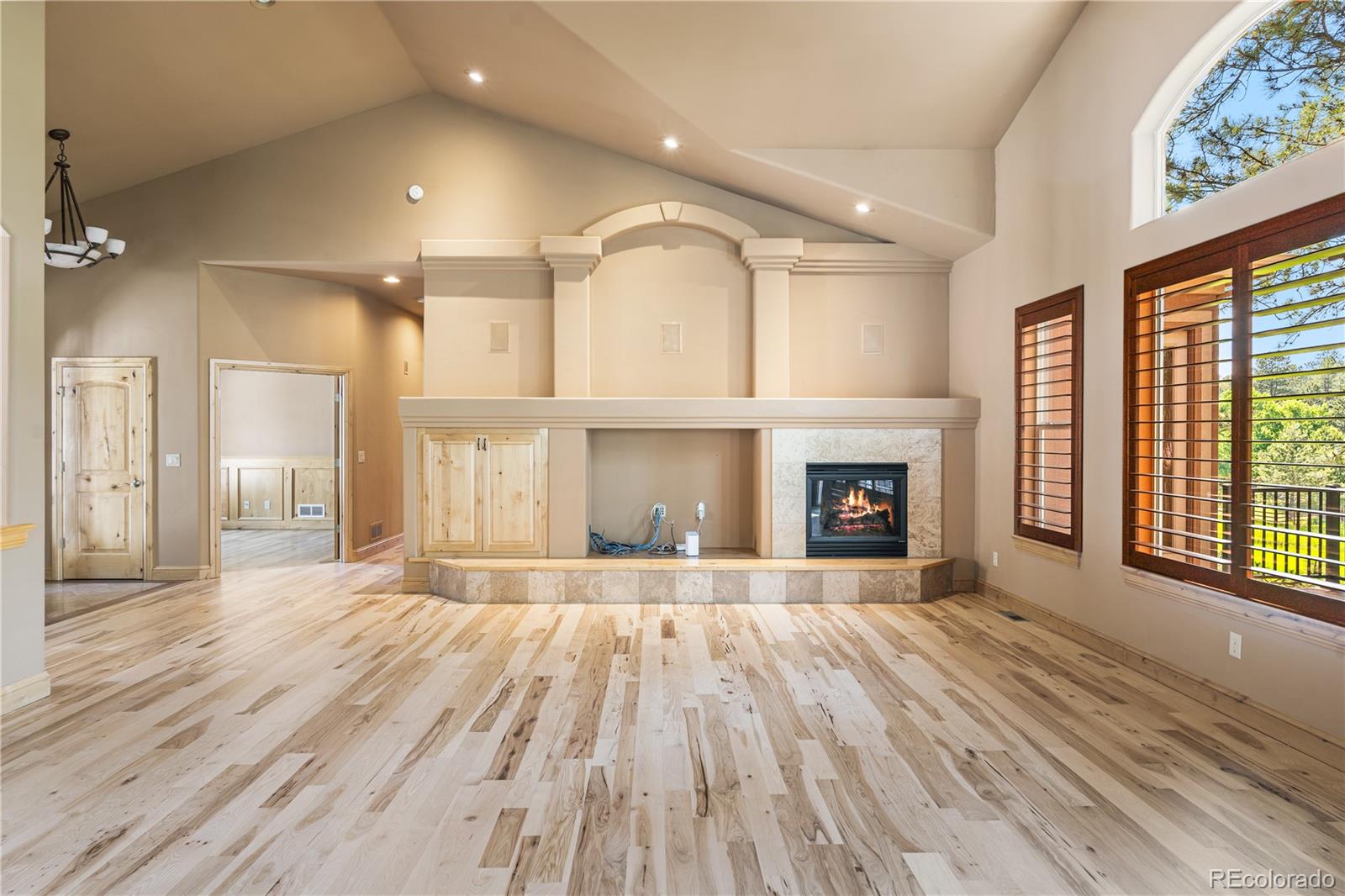 691 Cumberland Road Larkspur, CO 80118 - Photo 15 of 43 a view of an empty room with a fireplace and a window