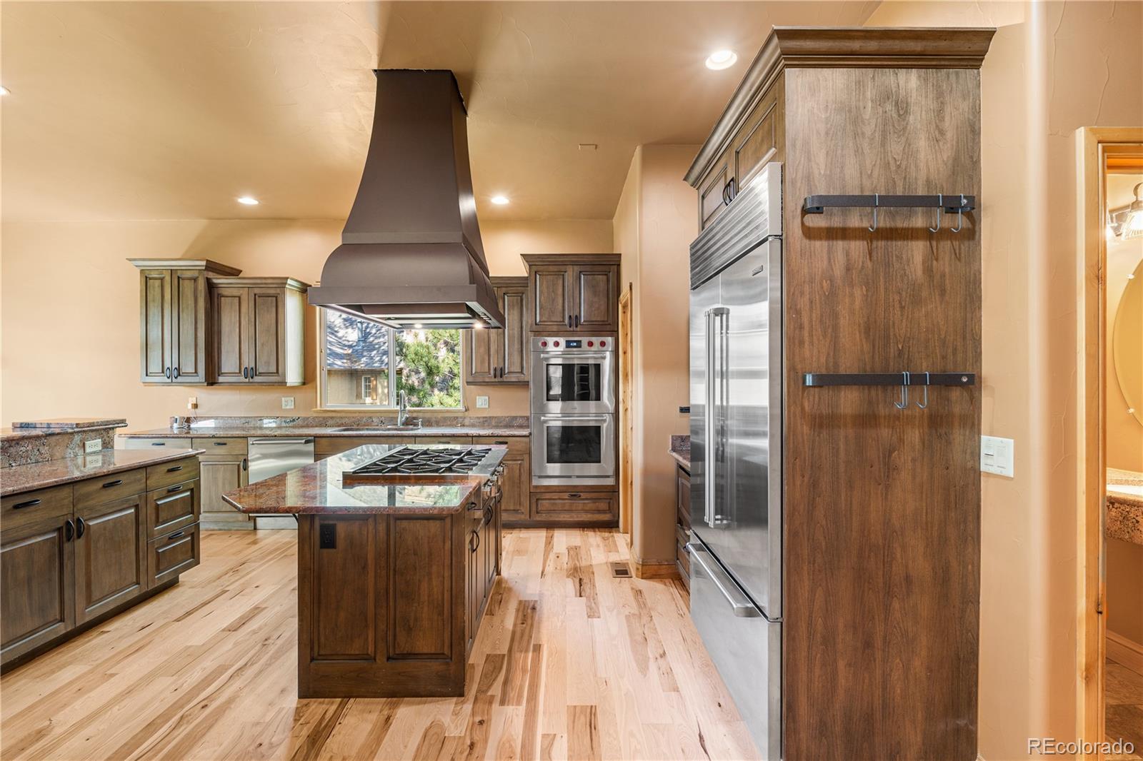 691 Cumberland Road Larkspur, CO 80118 - Photo 18 of 43 a kitchen with stainless steel appliances granite countertop a stove and a refrigerator